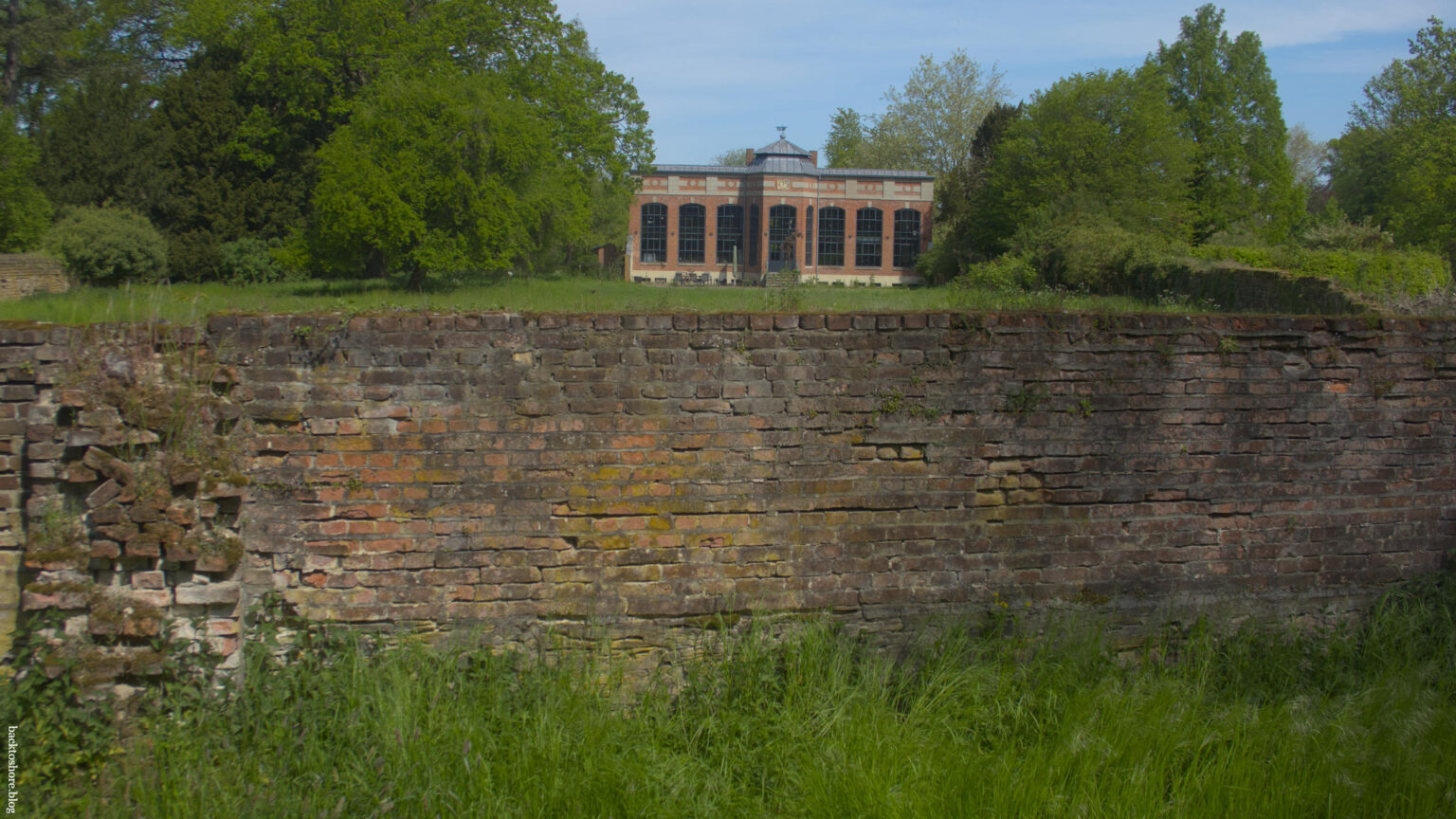 Manor housem brick wall in the forefront