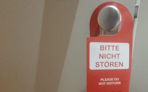 Red Do not disturb sign haning from a door knob of a open door