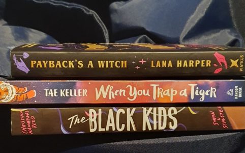 Stack of 3 books on a blue background: The Black Kids, How to catch a tiger, Payback's a witch