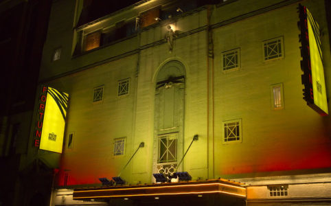 Fortune Theatre with the Operation Mincemeat marquee, basked in yellow light at night