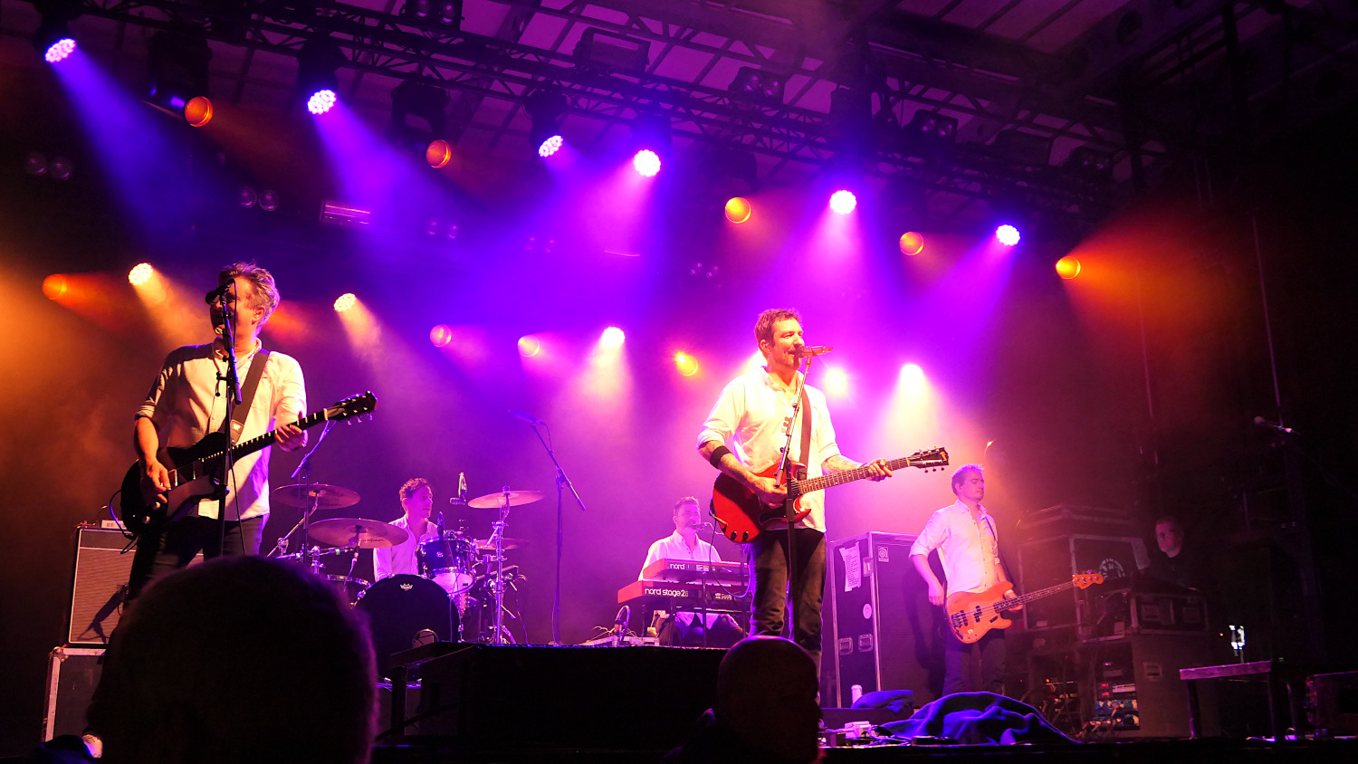 Frank Turner and the Sleeping Souls on stage. The lighting is pink / violet