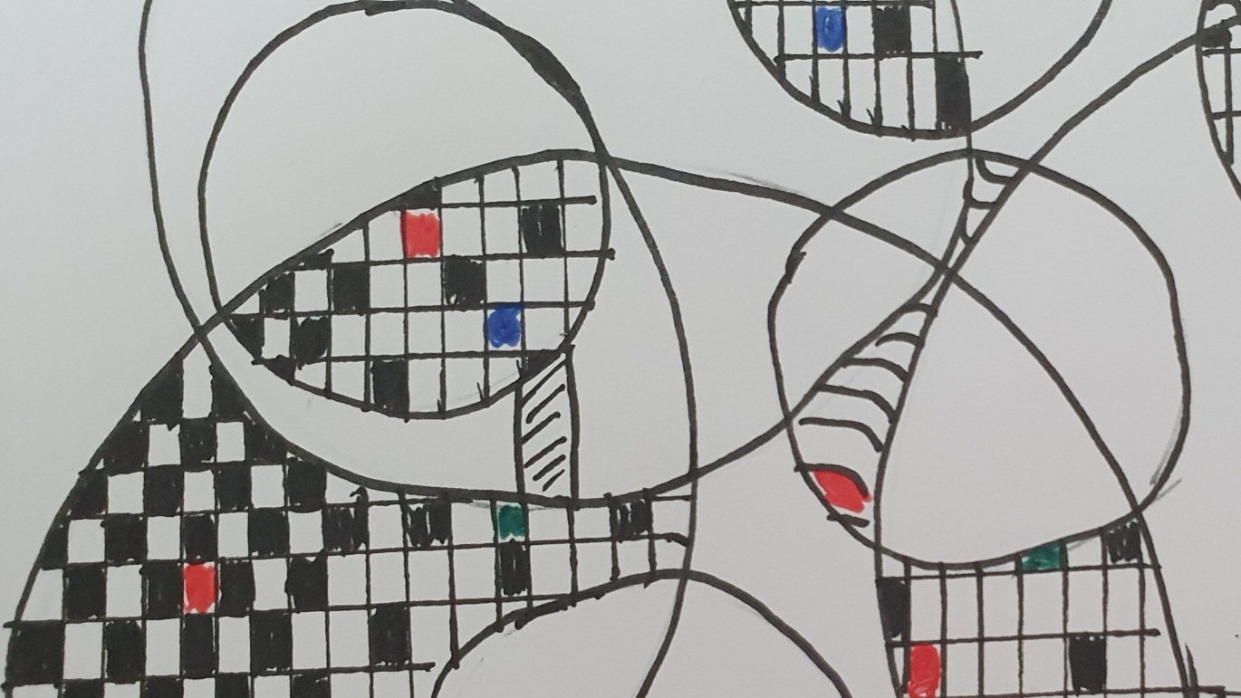 Photo of a zentagle drawing. Overlapping circles in various sizes, some of the overlapped areas are filled with black/white squares with the occassional blue or red square as well