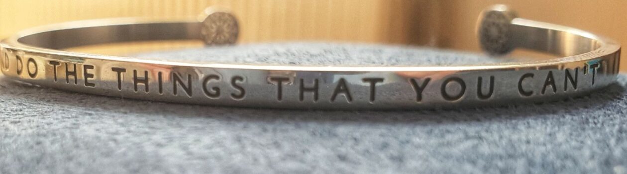 Photo of a bracelet, engraved with "Try and to the things that you can't"