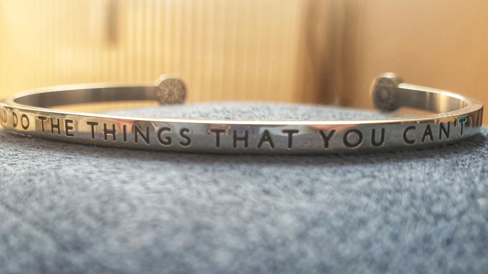 Photo of a bracelet, engraved with "Try and to the things that you can't"