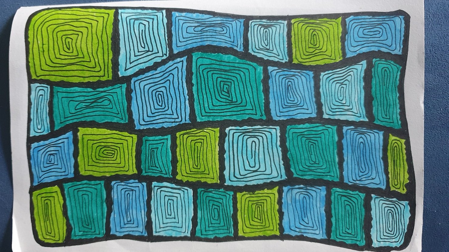 Zentangle: A page full of uneven squares with bold black lines. Coloured in with blue and green and filled with a spiralling black line