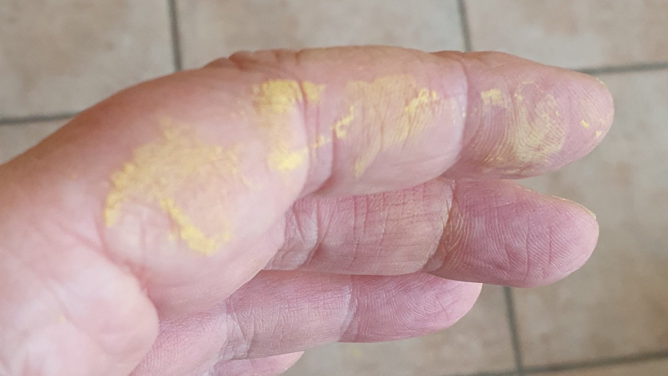 Photo a fingers with spackles of yellow paint