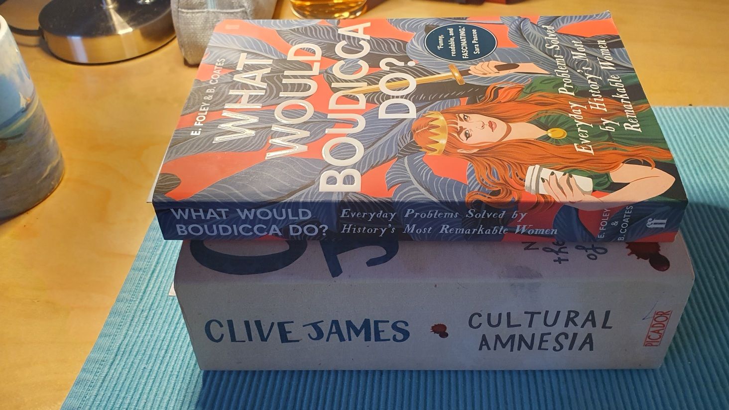 Photo of two books stacked on one another: Clive James Cultural Amnesia and What would Boudicca do