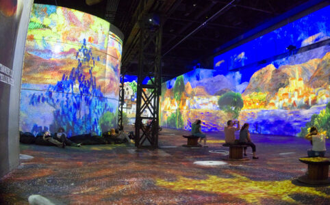 Inside a spacious former industrial space, colourful Dali art images projected on the walls