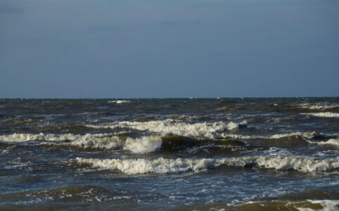 Sligtly choppy sea in the lower half, clear blue sky above