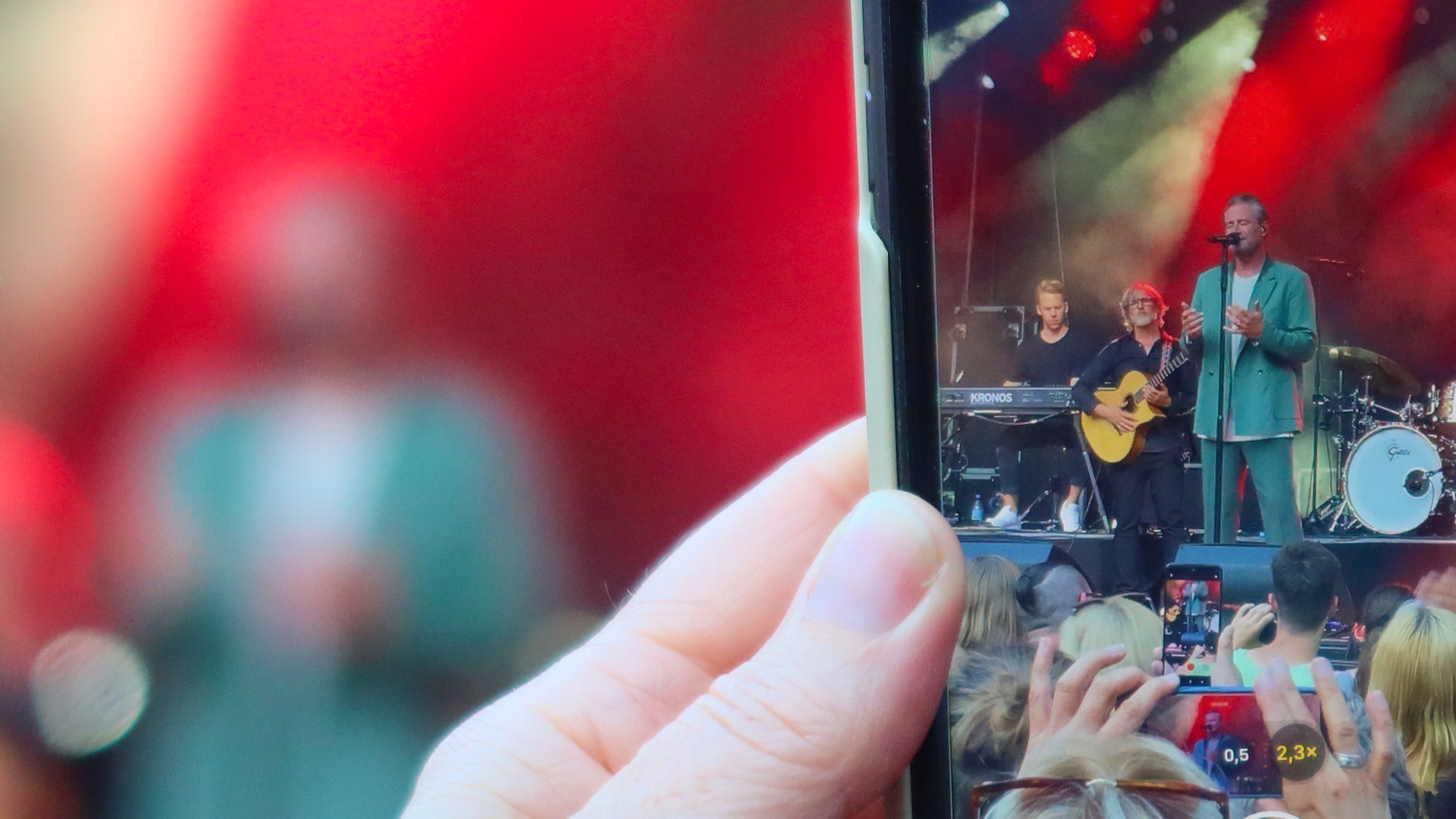 Photo of a phone camera taking a photo of Sasha on stage