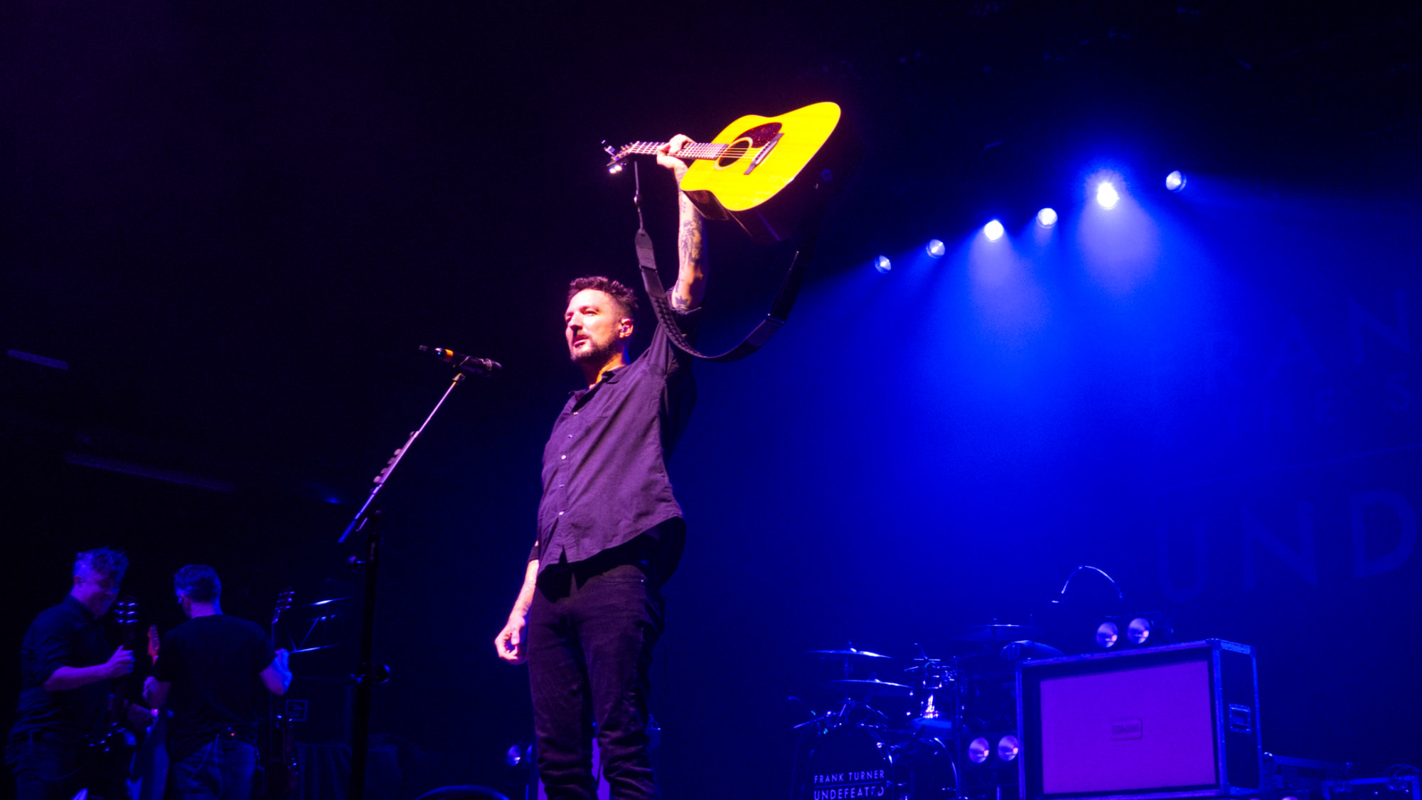 Frank Turner holding up his acoustic guitar