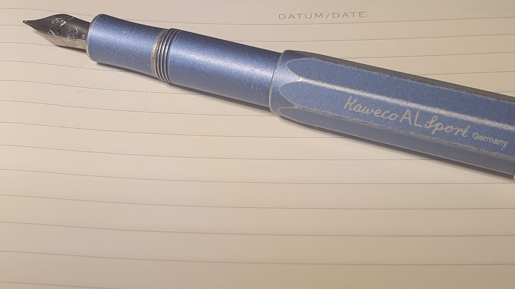 Kaweco Sports Fountain pen in denim metalic lying on an empty open journal page