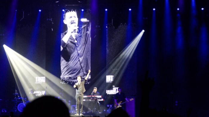 Frank Turner on stage with his fist raised up