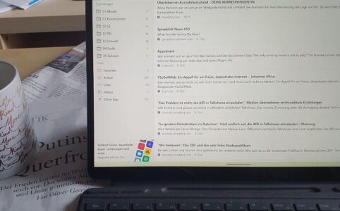 Laptop screen with bookmarked articles on paper newspaper