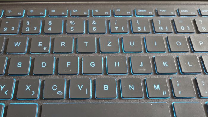 Photo of a tablet keyboard. Keyboard is lit up from behind with blue light